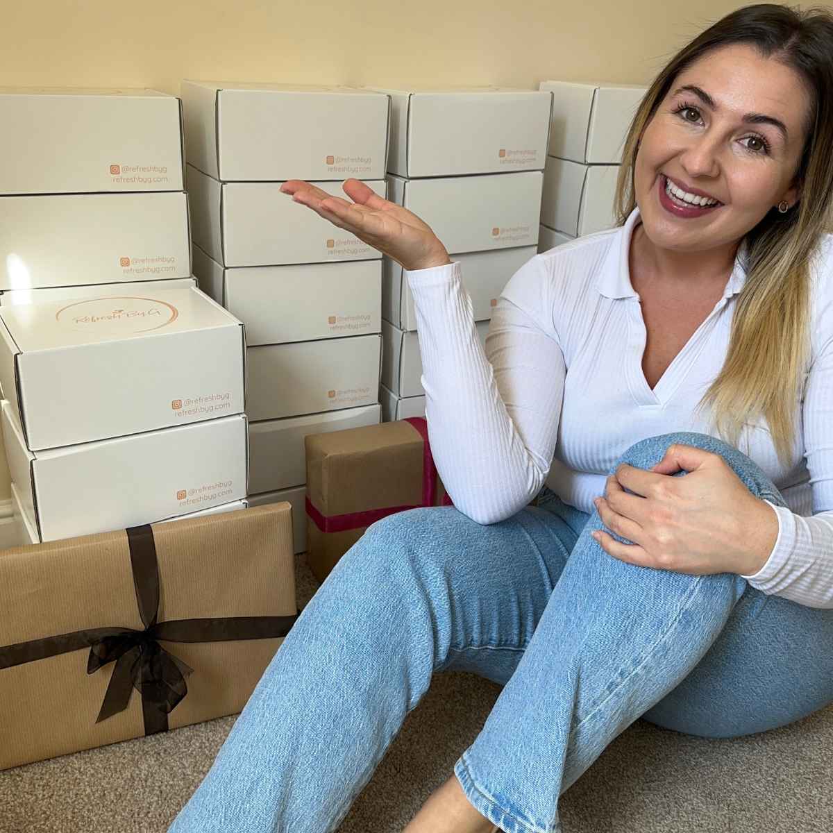 Refresh By G founder Georgina McGarry sitting on the floor with her first batch of Refresh By G gift boxes